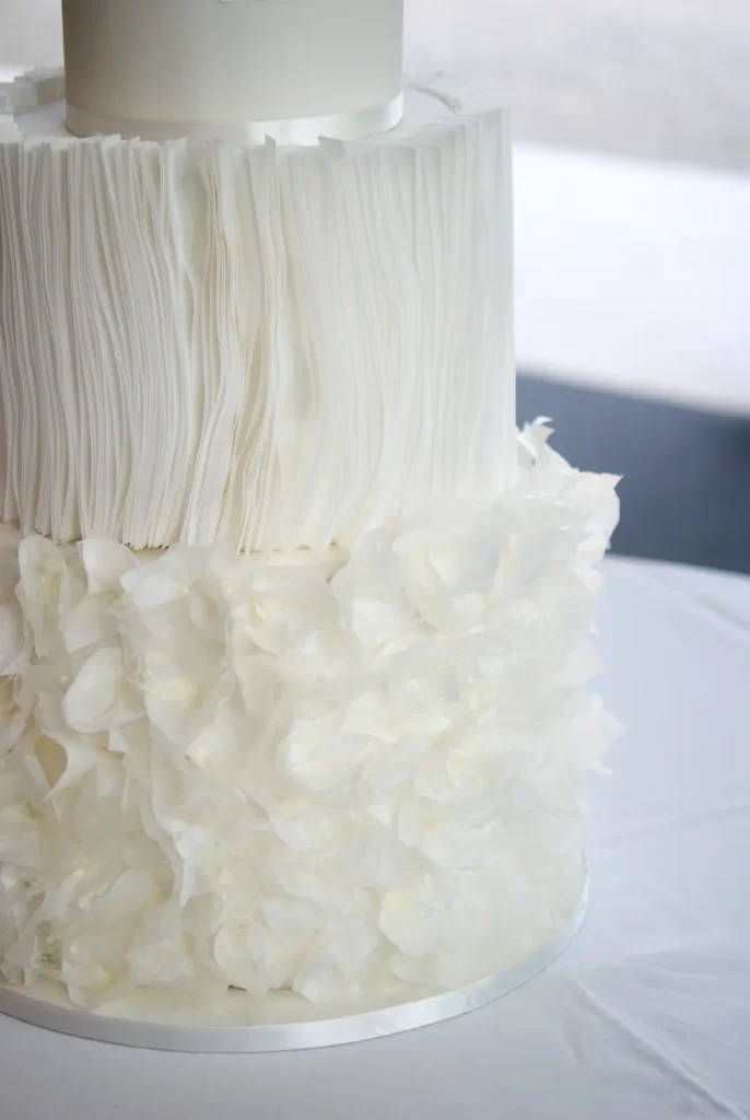Detail of hand-shaped wafer paper pleats on a wedding cake