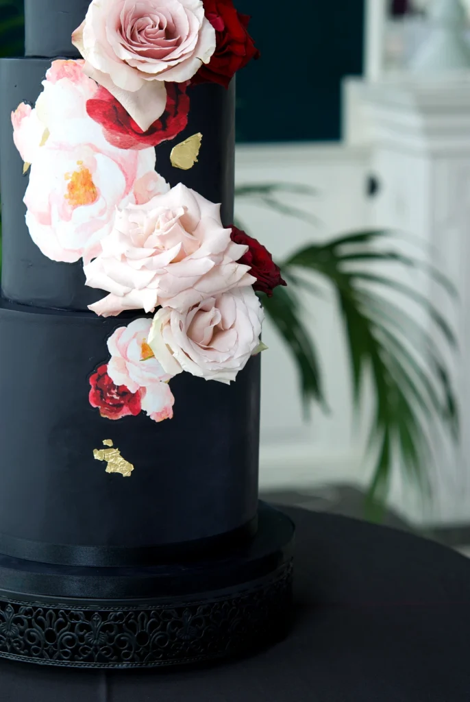 Close-up of watercolour roses on a black wedding cake