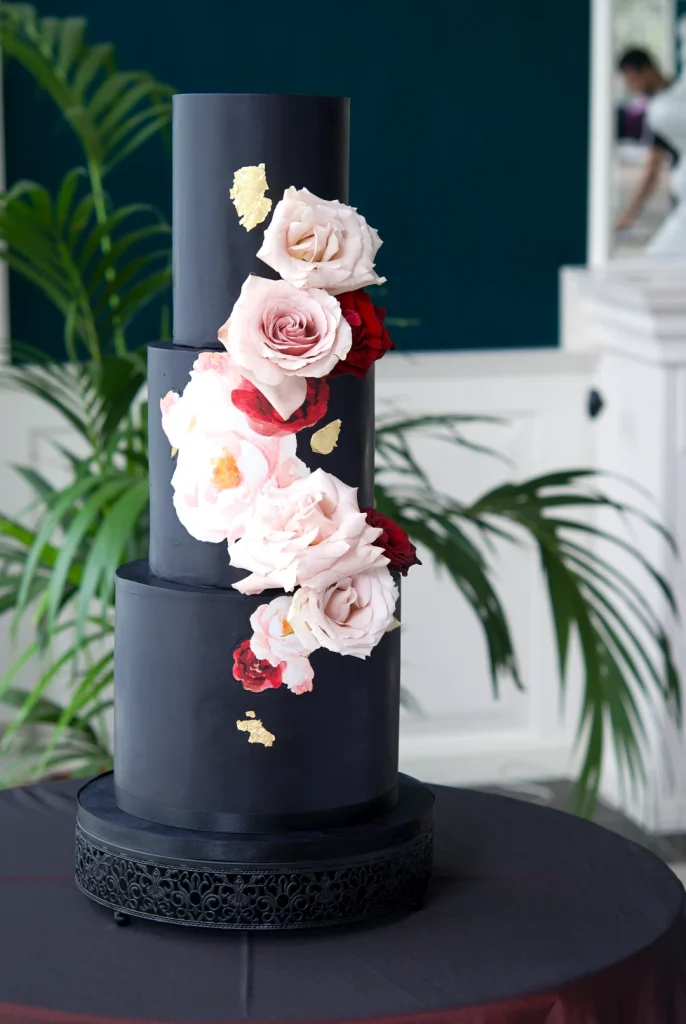 Black wedding cake with watercolour roses and gold leaf at Castell de Sant Marçal, Barcelona