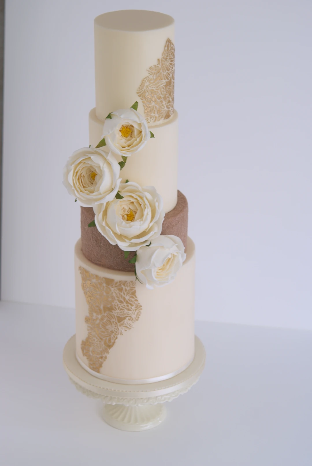 Ivory roses and gold wedding cake