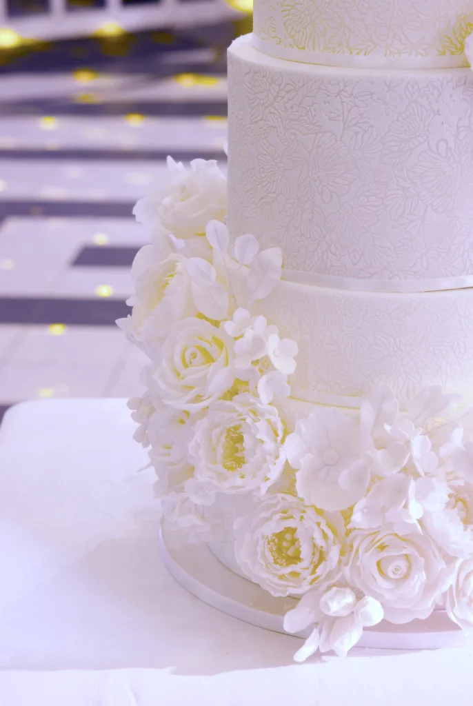Detail of edible lace and sugar hydrangeas on a white wedding cake