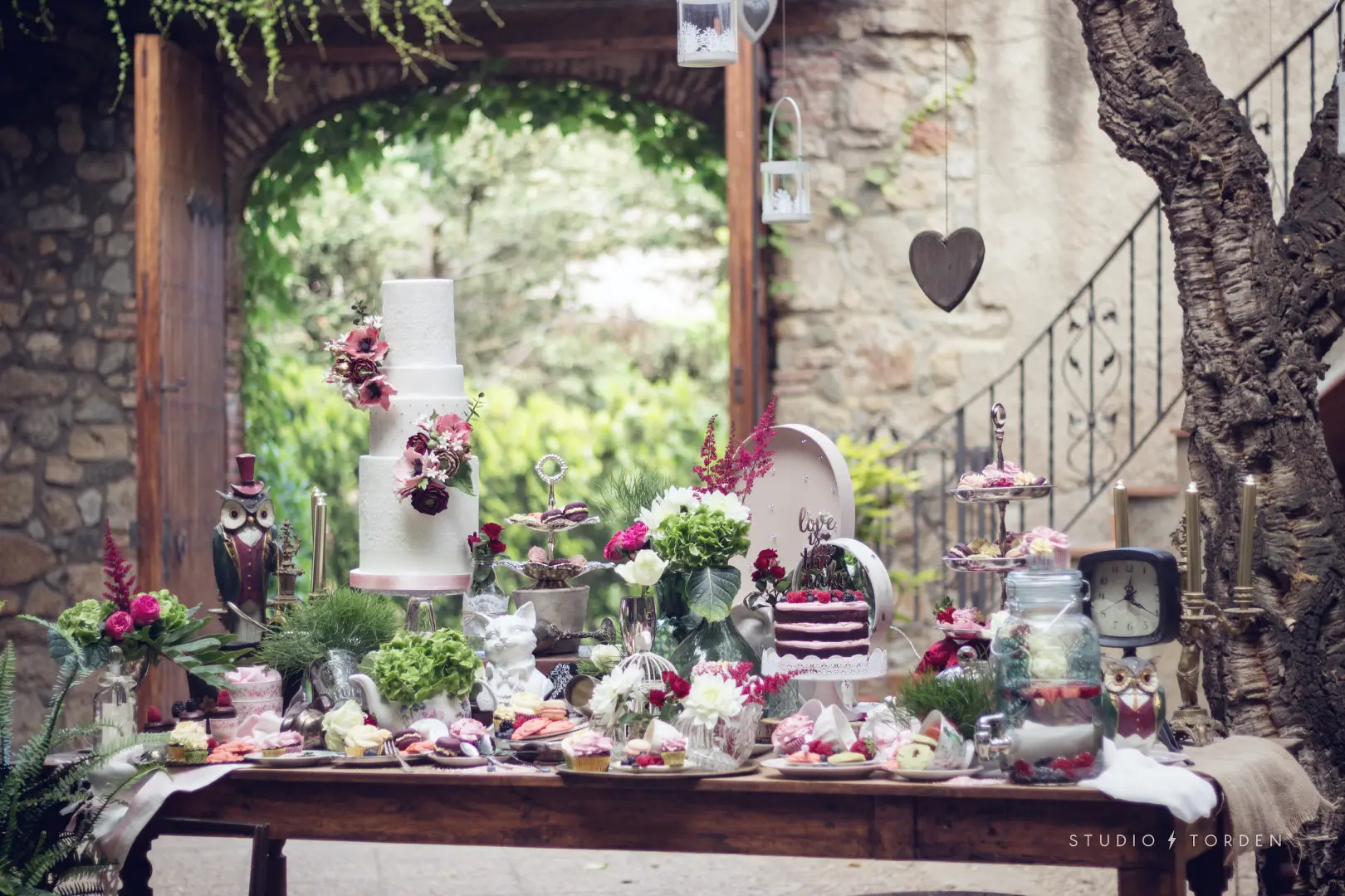 Montaje profesional de mesa dulce con tarta de varios pisos y decoración floral, ejemplo de temario en la Master Class de Mericakes.