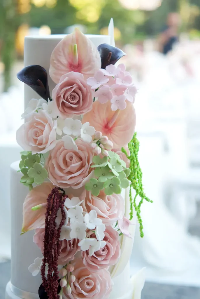 Close-up of sugar anthuriums, dark calla lilies and pink roses on the Botanical Blush wedding cake by Mericakes