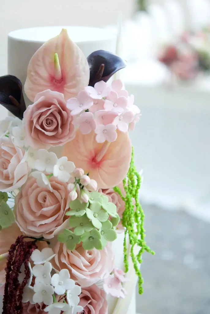 Botanical Blush wedding cake displayed beside the guest tables at Castell de Sant Marçal