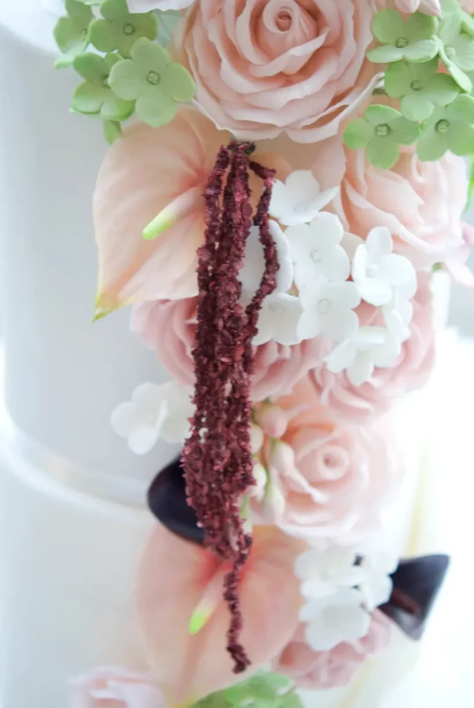 Close-up of hanging sugar amaranthus and blush roses on a luxury wedding cake in Barcelona