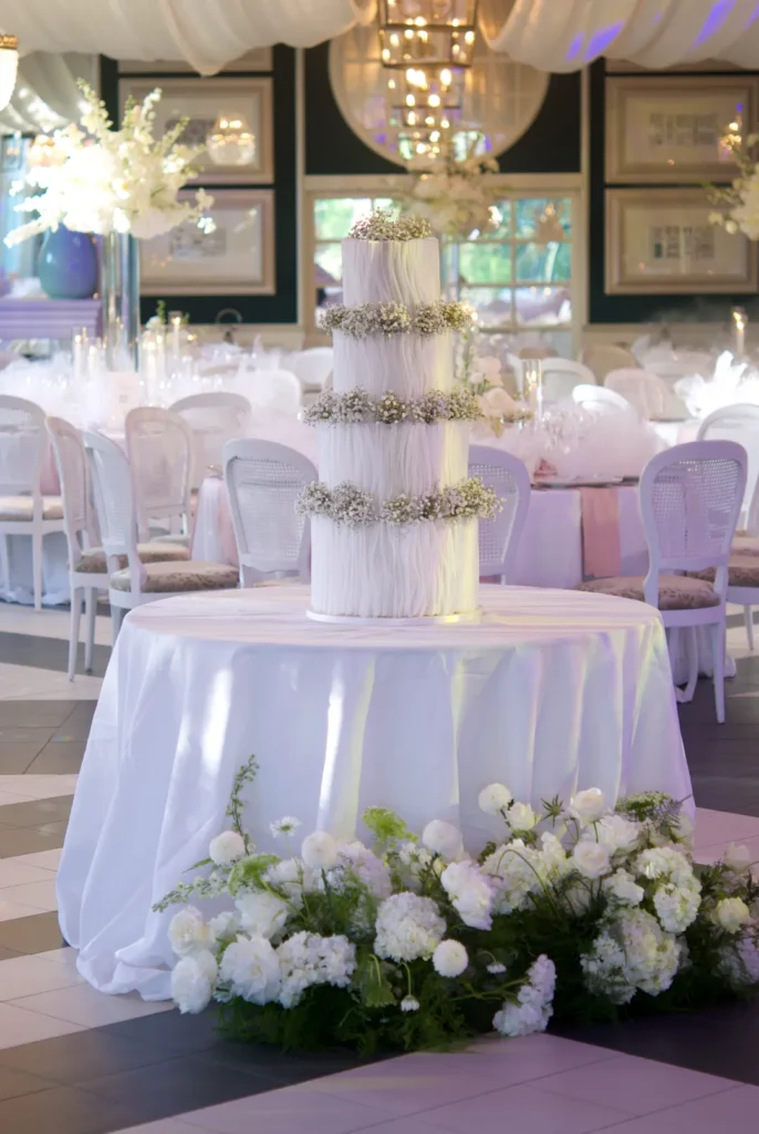 Four-tier white wedding cake for more than 200 guests at Castell de Sant Marçal
