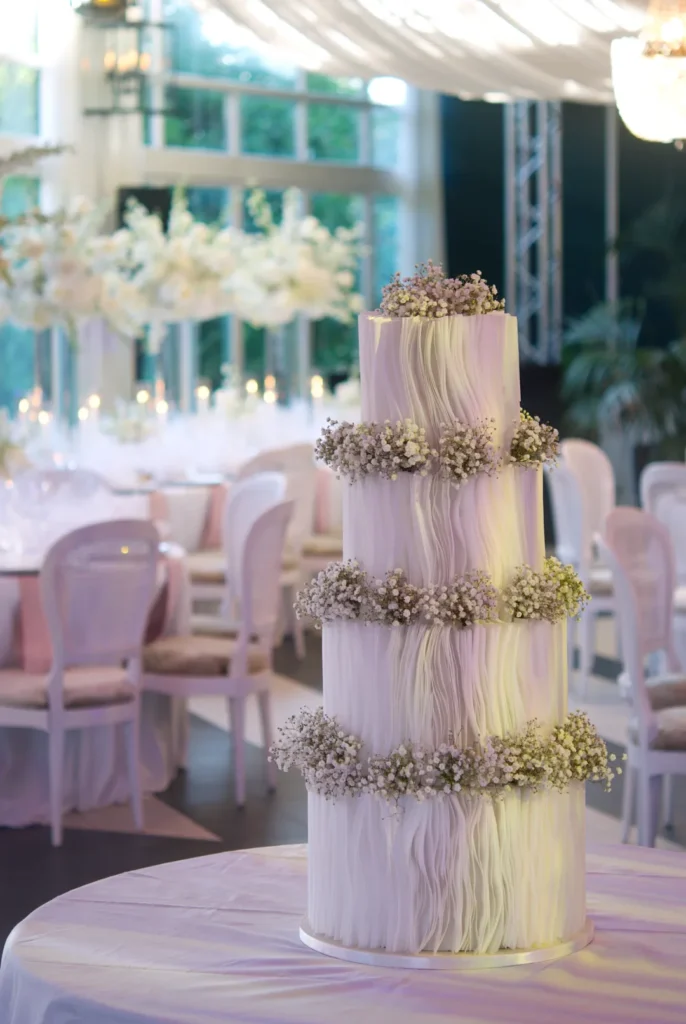 Four-tier luxury wedding cake with hand-placed wafer paper strips at Castell de Sant Marçal, Barcelona