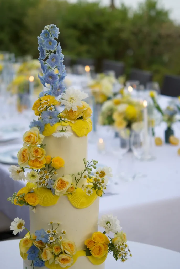 Detail of fresh cosmos, roses and daisies arranged by hand on a wedding cake